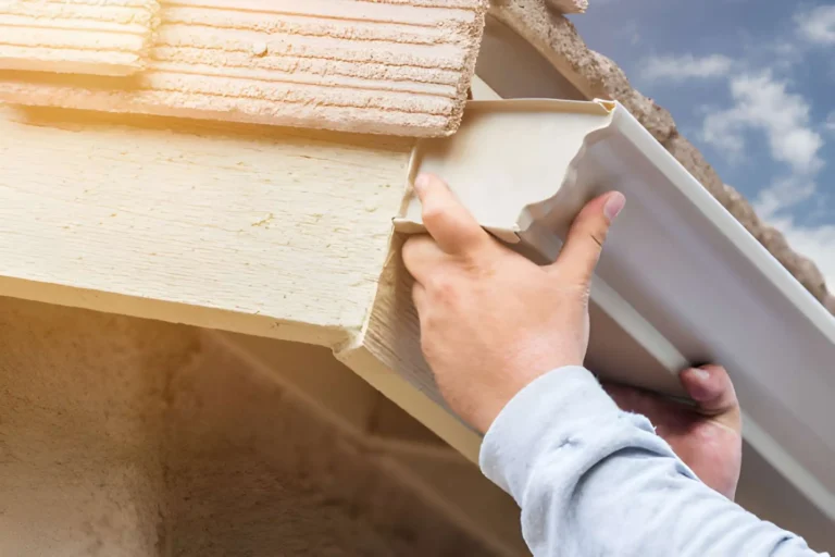 Seamless gutter installation - Professional installer attaching aluminum gutter run with hidden hangers to fascia board - Roof Installation guide