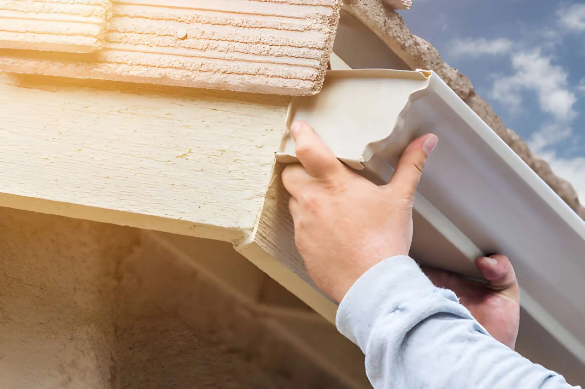 Seamless gutter installation - Professional installer attaching aluminum gutter run with hidden hangers to fascia board - Roof Installation guide