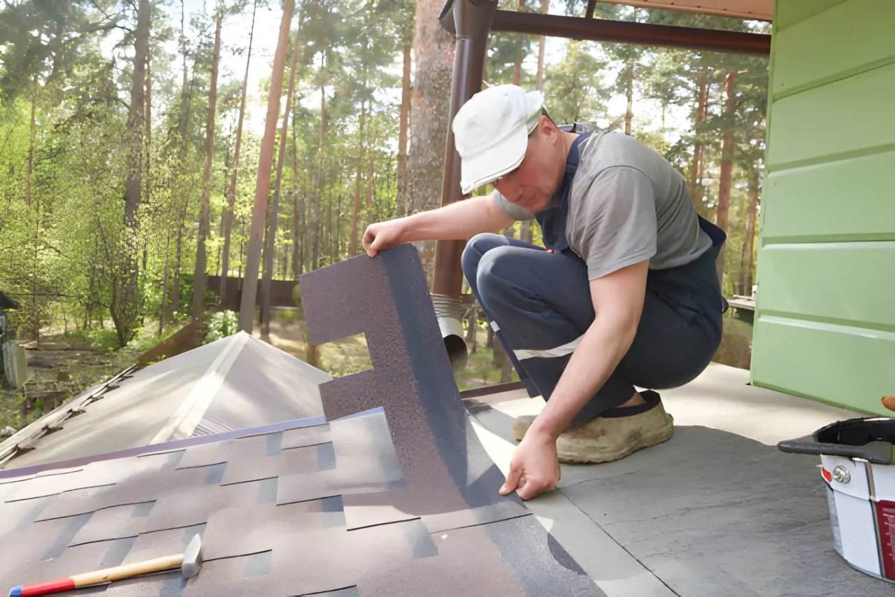Plastic composite shingles being installed on roof deck - Installer demonstrating correct nail placement within manufacturer fastening zone - Roofing installation detail