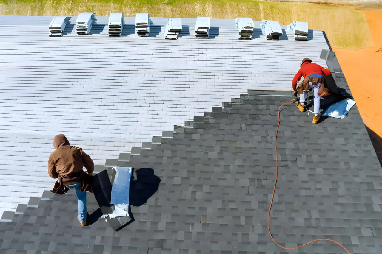 Roofing company crew installing asphalt shingles on residential home -
Three workers with fall protection harnesses completing roof replacement
- Professional roofing team