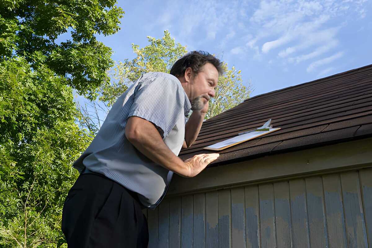 Professional inspecting roof for hail damage