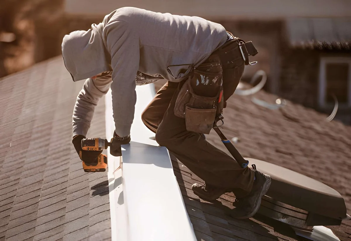  damaged ridge cap shingle being replaced by roofer